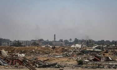 Smoke billows over buildings flattened by Israeli strikes
