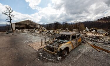 A car sits charred Saturday near the remains of the Swiss Chalet Hotel after both were destroyed by the South Fork Fire in the mountain village of Ruidoso
