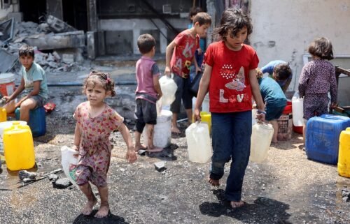 Palestinian children fill containers with water in Jabalya