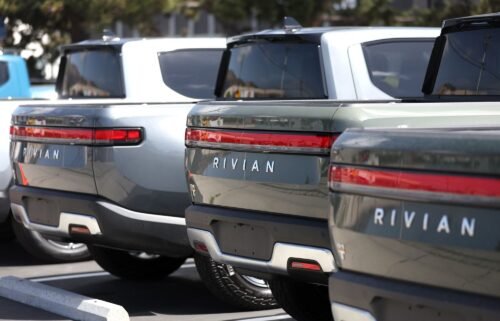 Rivian electric pickup trucks sit in a parking lot at a Rivian service center in May 2022 in South San Francisco