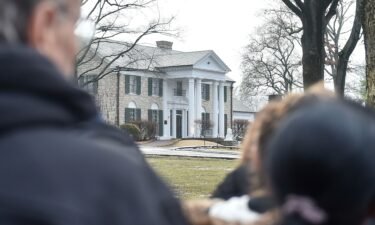 Fans gather outside Graceland to pay their respects at the memorial for Lisa Marie Presley in January 2023 in Memphis