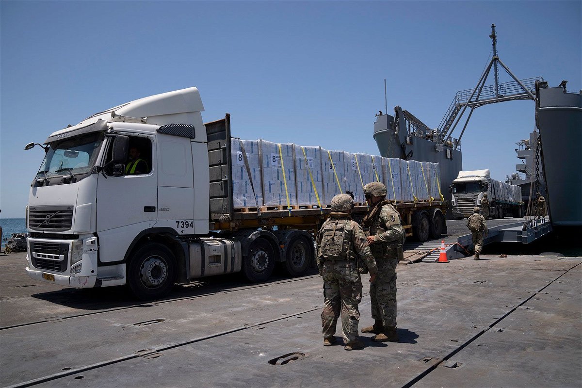 <i>Leo Correa/AP via CNN Newsource</i><br/>U.S. Army soldiers stand next to trucks arriving loaded with humanitarian aid at the U.S.-built floating pier Trident before reaching the beach on the coast of the Gaza Strip