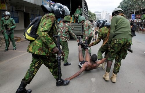 Police officers detain a man during a demonstration over police killings of people protesting against Kenya's finance bill