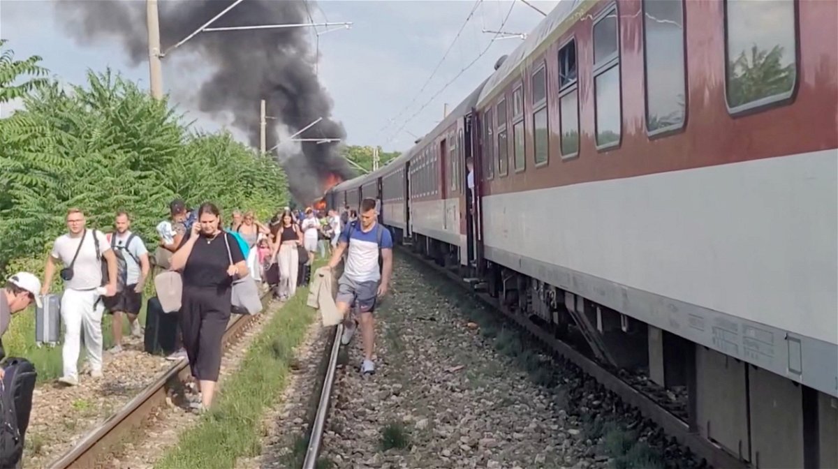<i>Katarina Molnarova Perlacosmetic/UGC/Reuters via CNN Newsource</i><br/>Smoke billows from a fire while people evacuate from a train