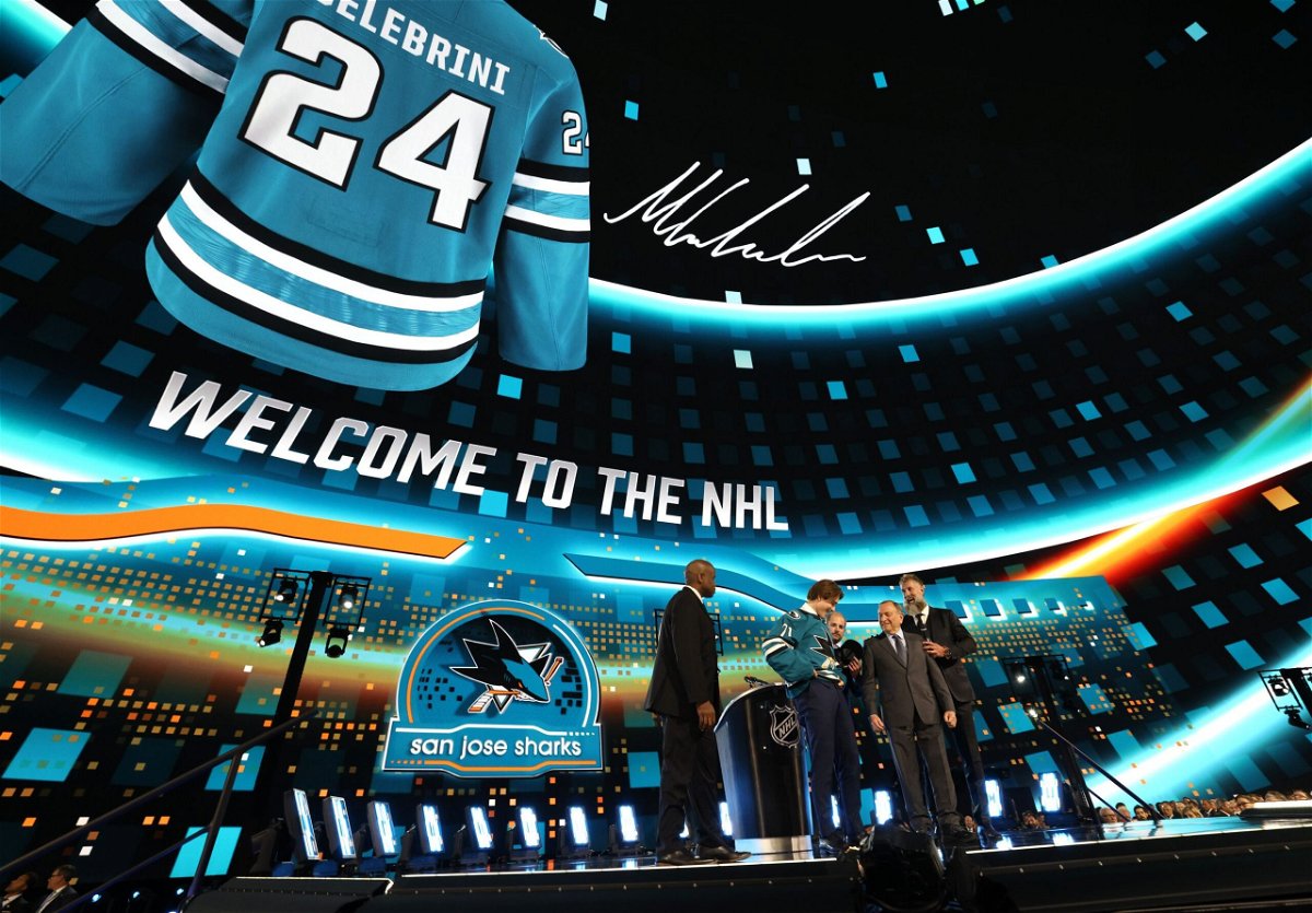 <i>Dave Sandford/NHLI/Getty Images via CNN Newsource</i><br/>Macklin Celebrini puts on a jersey after being selected first overall by the San Jose Sharks during the first round of the 2024 NHL Draft at Sphere on June 28