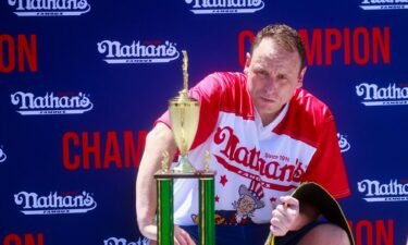 Joey Chestnut sits with the trophy and belt after he won first place