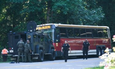 A hijacked commuter bus sits in the road where it was stopped after a lengthy police chase on June 11.