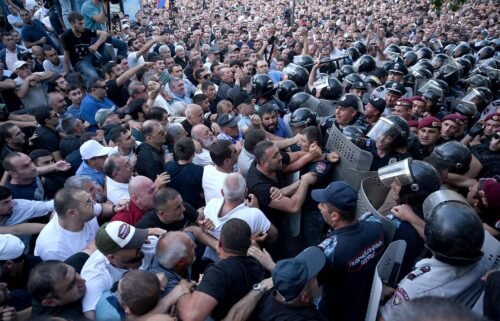 Anti-government protesters clash with police outside the parliament in Yerevan