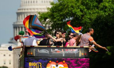 Parade participants wave from the top of a double decker tour bus as Capital Pride Parade makes its way down Pennsylvania Ave. NW on June 8.