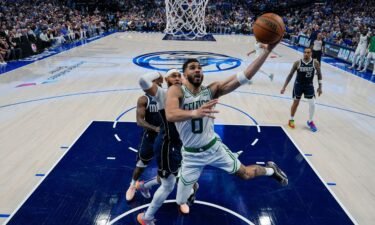 Boston Celtics forward Jayson Tatum (0) goes up for a basket in front of Dallas Mavericks forward P.J. Washington during the first half in Game 3 of the NBA basketball finals