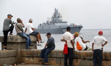 People watch a ship belonging to the Russian Navy flotilla arrive at the port of Havana on Wednesday