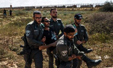 Israeli security forces apprehend a protester from the Tsav 9 movement as the group performs a sit-in in an attempt to block aid shipments from getting into Gaza