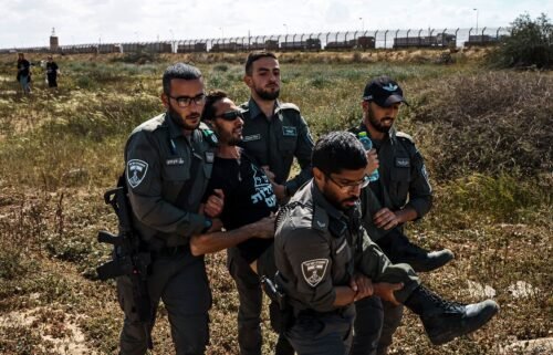 Israeli security forces apprehend a protester from the Tsav 9 movement as the group performs a sit-in in an attempt to block aid shipments from getting into Gaza