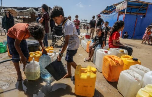 Palestinians queue up to receive clean drinking water distributed by aid organizations in Deir al-Balah.