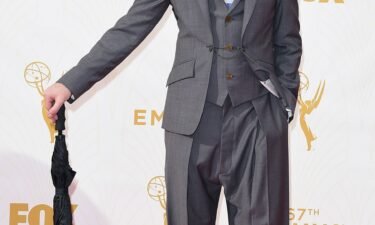 Alan Cumming attends the 67th Primetime Emmy Awards in a Vivienne Westwood suit and black Crocs.