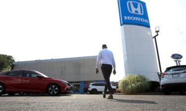 A worker walks through the lot of Paragon Honda and Acura car dealership in the Queens borough of New York in July 2021. Car dealerships across the United States and Canada are being impacted due to cyber incidents at CDK Global.