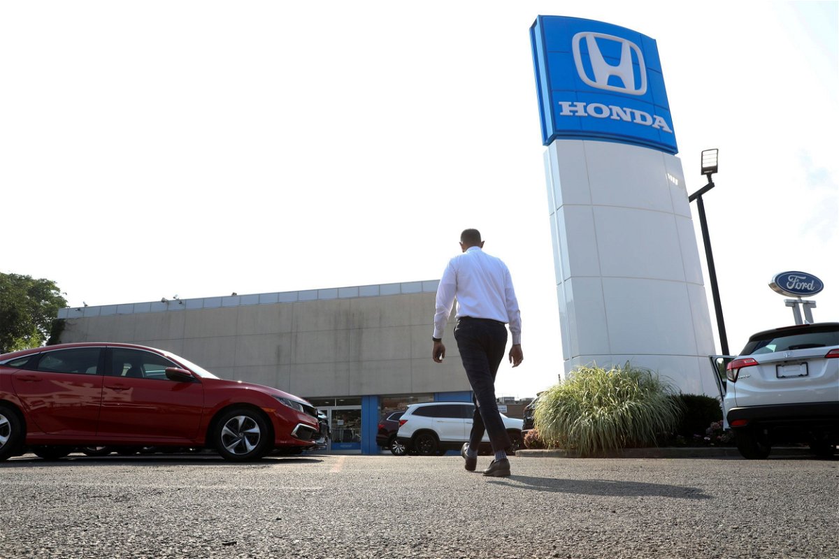 <i>Bess Adler/Bloomberg/Getty Images/File via CNN Newsource</i><br/>A worker walks through the lot of Paragon Honda and Acura car dealership in the Queens borough of New York in July 2021. Car dealerships across the United States and Canada are being impacted due to cyber incidents at CDK Global.