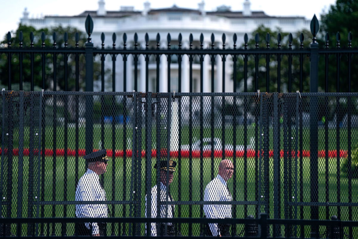 <i>Kent Nishimura/Getty Images via CNN Newsource</i><br/>Law enforcement officials walk around the security fencing set around the White House complex on June 7 in Washington