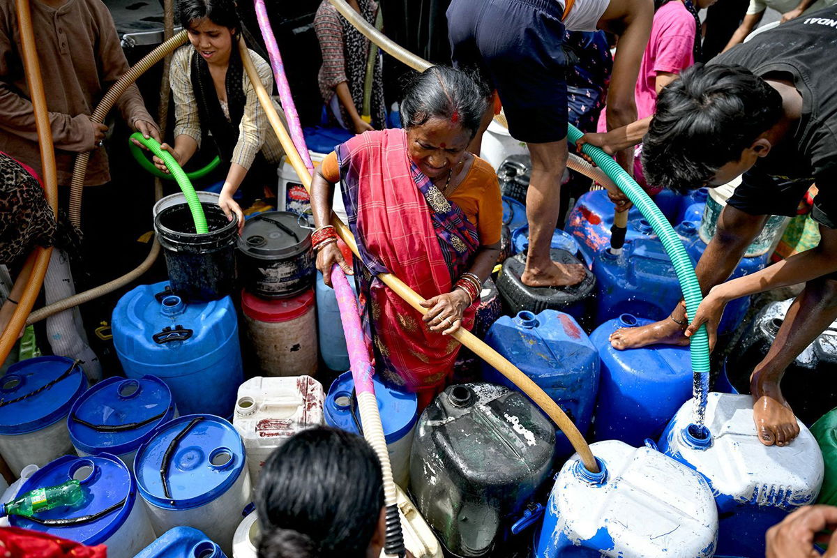 <i>Money Sharma/AFP/Getty Images via CNN Newsource</i><br/>Residents fill their containers with water supplied by a municipal tanker in New Delhi on June 19.