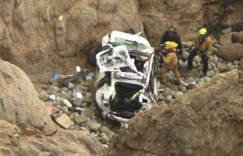 This image from the San Mateo County Sheriff's Office shows the Tesla on a rocky beach below the cliffs
