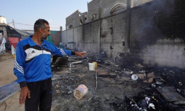 A Palestinian man points to ashes in a tented area the day after a strike on Mawasi.