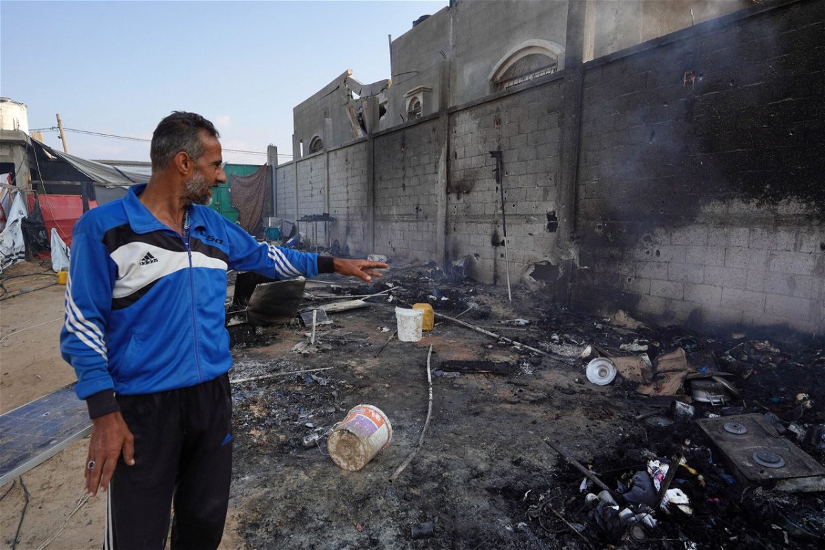 <i>Bashar Taleb/AFP/Getty Images via CNN Newsource</i><br/>A Palestinian man points to ashes in a tented area the day after a strike on Mawasi.