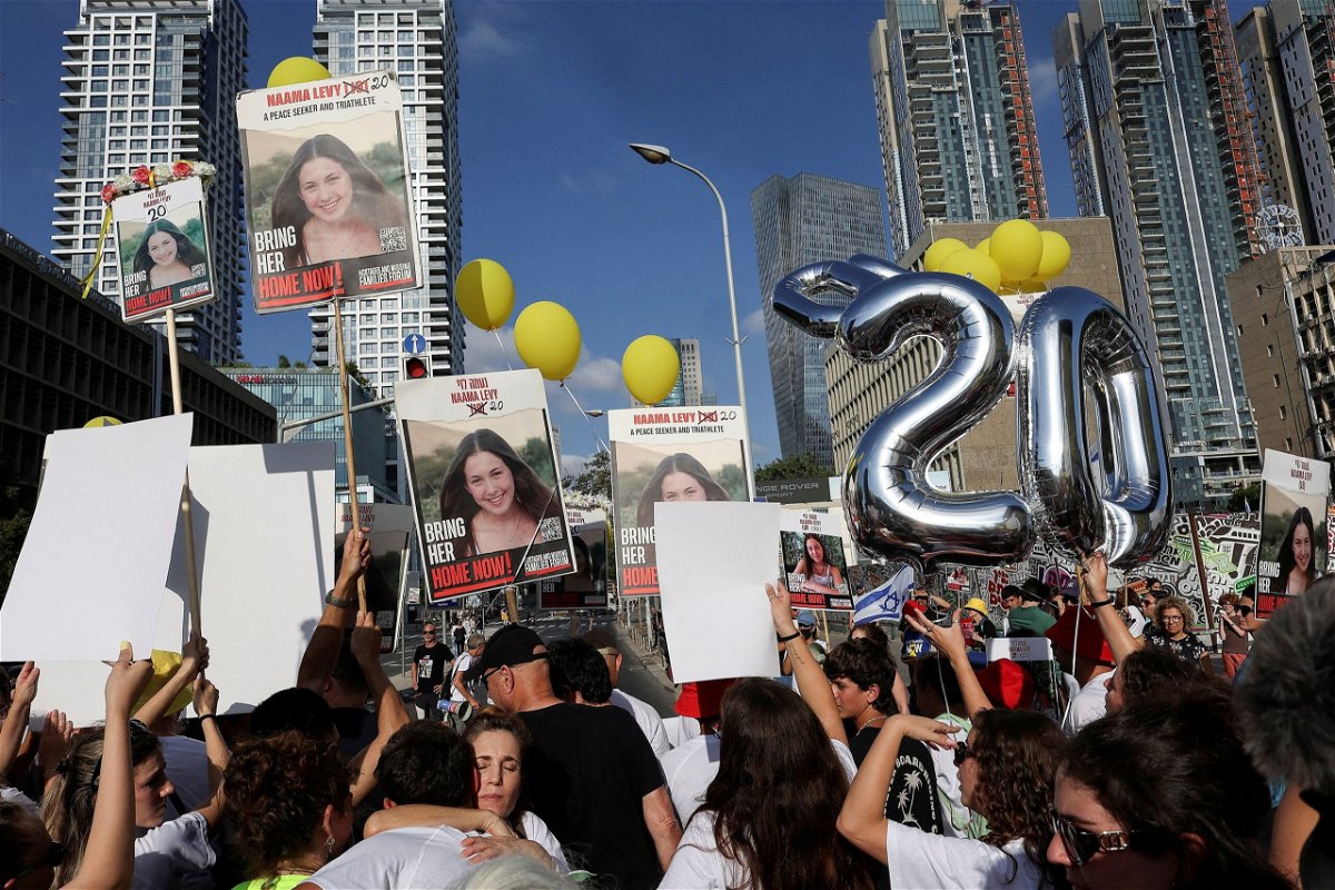 <i>Eloisa Lopez/Reuters via CNN Newsource</i><br/>People hold signs and balloons