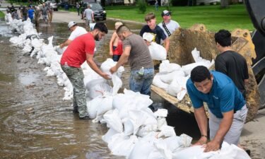 Volunteers stack sandbags in the wake of flooding from the Big Sioux River