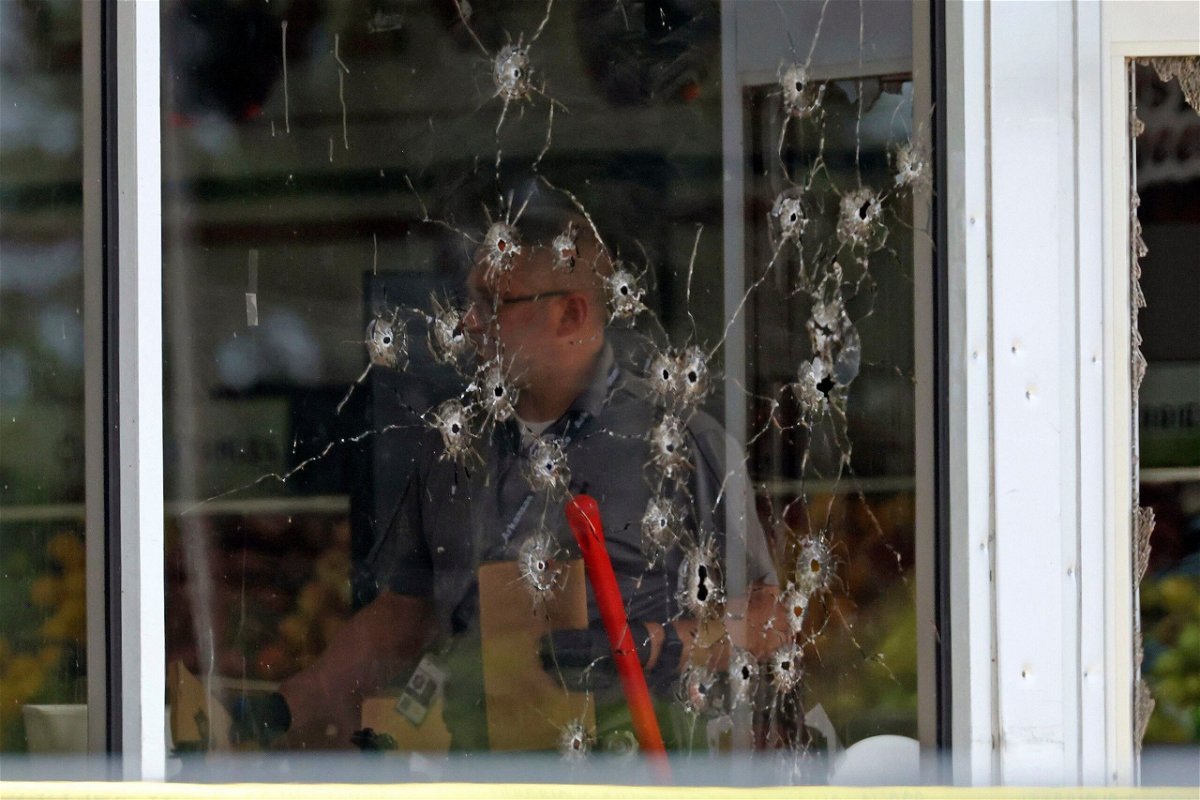 <i>Colin Murphey/Arkansas Democrat-Gazette/AP via CNN Newsource</i><br/>Damage can be seen to a front window as law enforcement officers work the scene of a shooting at the Mad Butcher grocery store in Fordyce