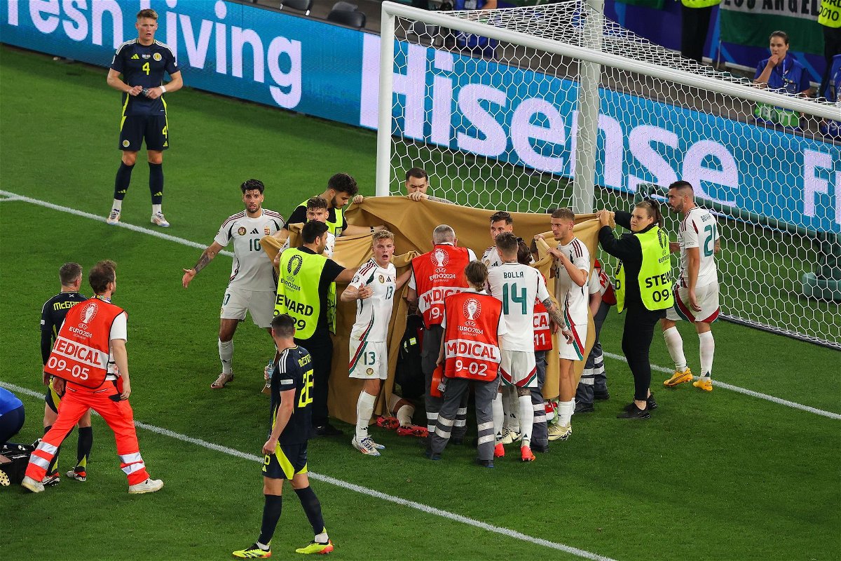 <i>James Gill/Danehouse/Getty Images via CNN Newsource</i><br/>Players and stewards hold sheets to shield Barnabás Varga while he receives medical treatment.