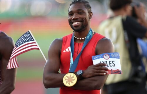 Lyles poses with the flag and his gold medal after the race.