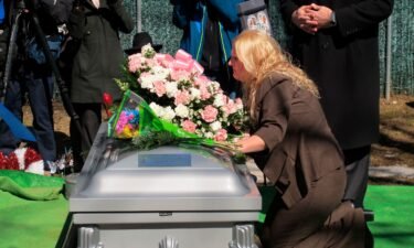 Mari Gilbert kneels over the coffin of her daughter Shannan Gilbert at Amityville Cemetery in March 2015.