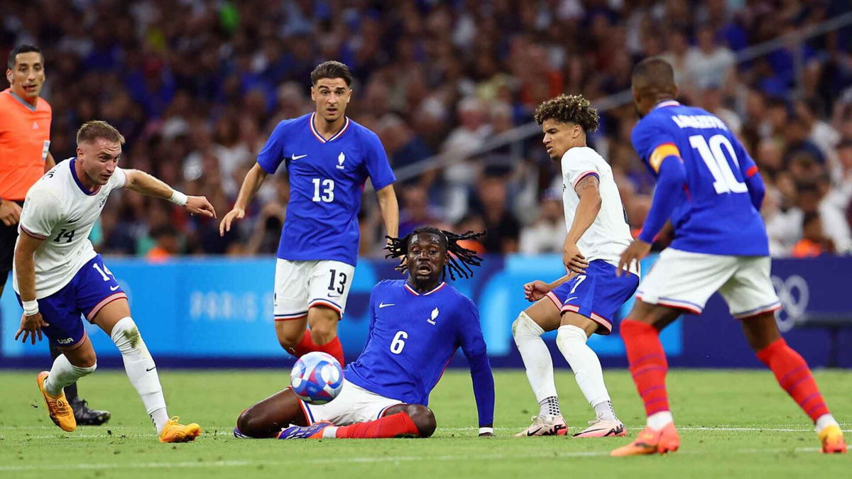 USMNT and France players look at the ball.