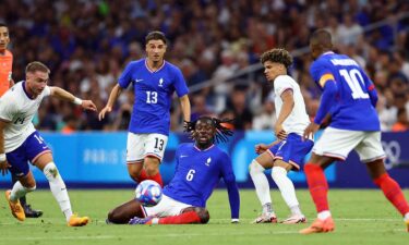 USMNT and France players look at the ball.