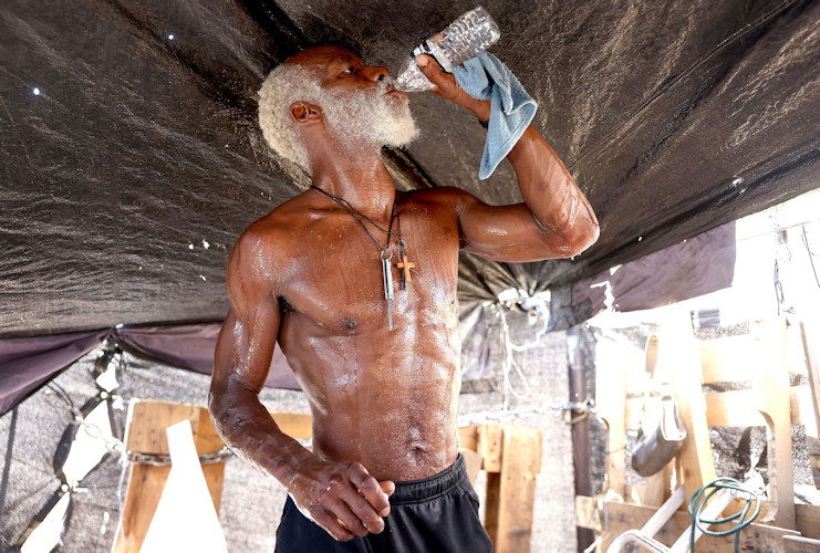 A man drinking water in his tent in