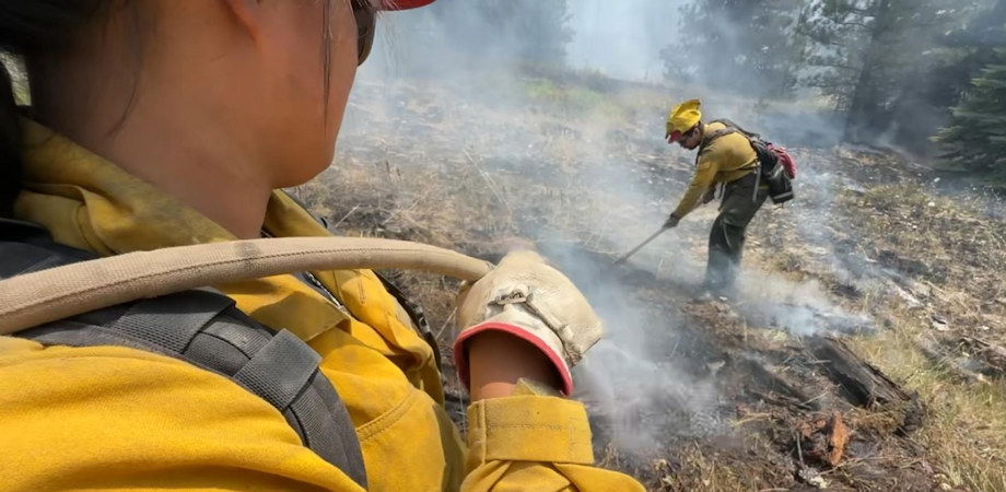 Firefighters mop up to secure the fire's edge. Mop up is a crucial component of ensuring a wildfire is contained.