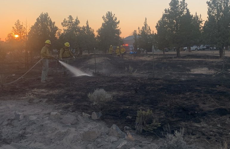 Firefighters hose down part of the Quail Fire that burned over 8 acres at Crooked River Ranch Thursday evening