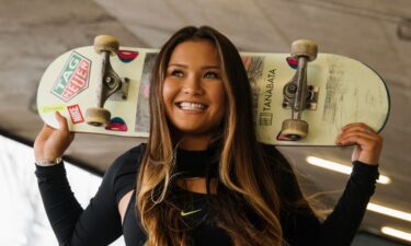 Sky Brown poses with her skateboard.