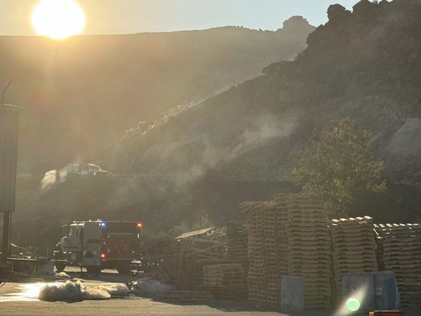 Crews from several agencies helped contain a wind-whipped brush fire behind the former Warm Springs mill on Monday.