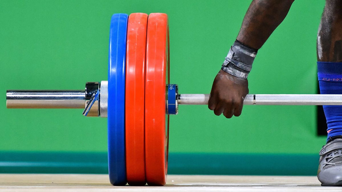A weightlifter clutches the barbell