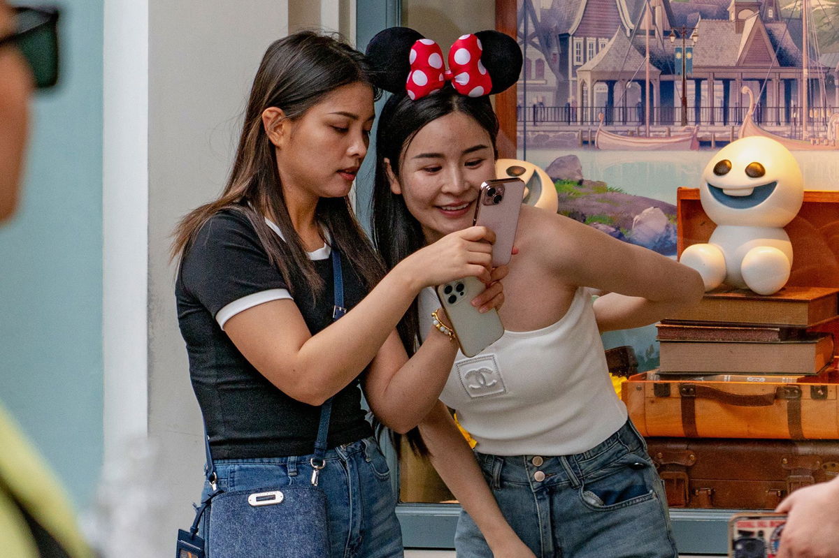 <i>Noemi Cassanelli/CNN via CNN Newsource</i><br/>Many visitors at the park post photos to social media wearing Disney paraphenelia. Some find it a welcome reprieve from the pressures of life outside.