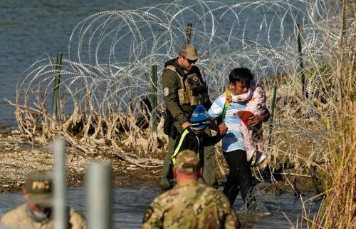 Migrants are taken into custody by officials at the Texas-Mexico border