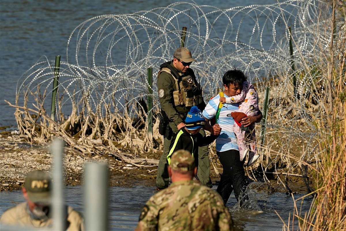 <i>Eric Gay/AP/File via CNN Newsource</i><br/>Migrants are taken into custody by officials at the Texas-Mexico border