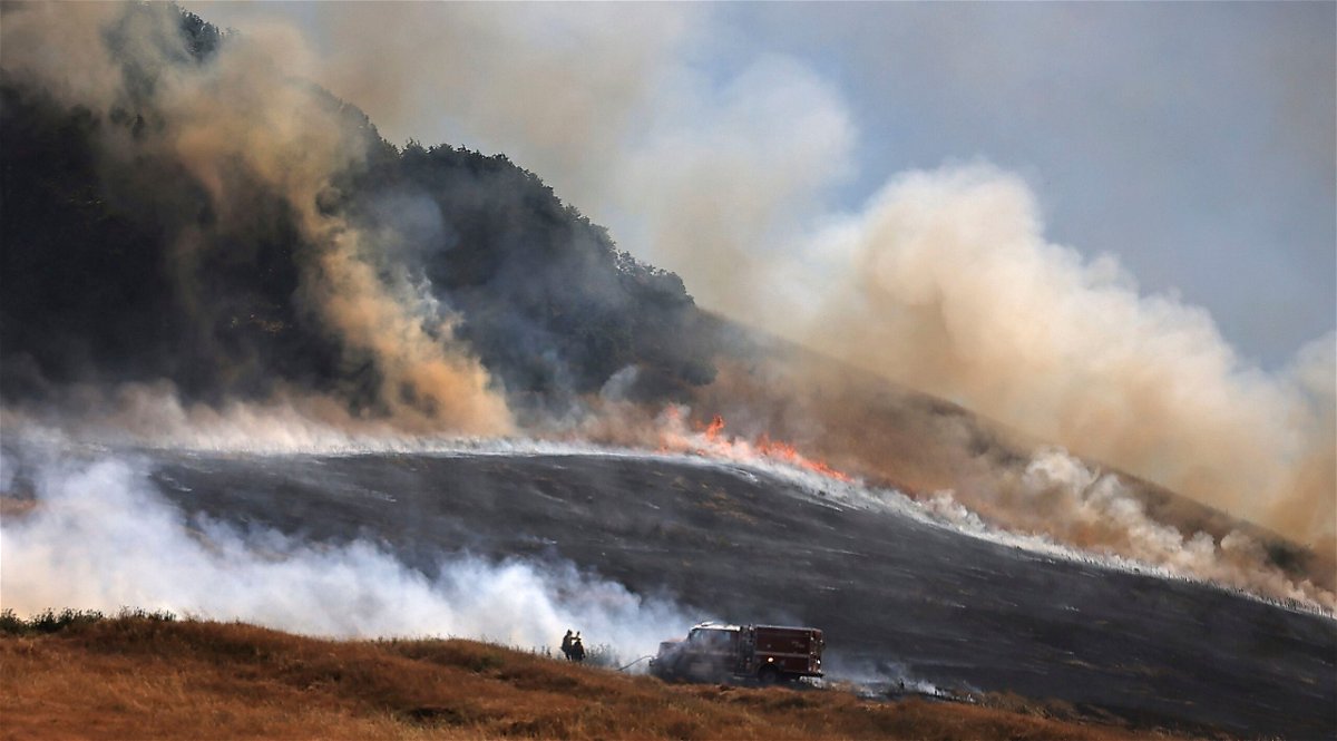 <i>Kent Porter/AP via CNN Newsource</i><br/>A wildfire spreads uphill west of Petaluma