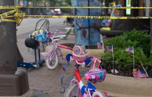 Police crime tape is seen around the area where children's bicycles and baby strollers stand near the scene of the Fourth of July parade shooting that killed seven people in Highland Park