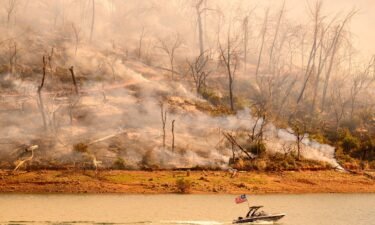 A boat moves along Lake Oroville as the Thompson Fire continues to burn in Oroville