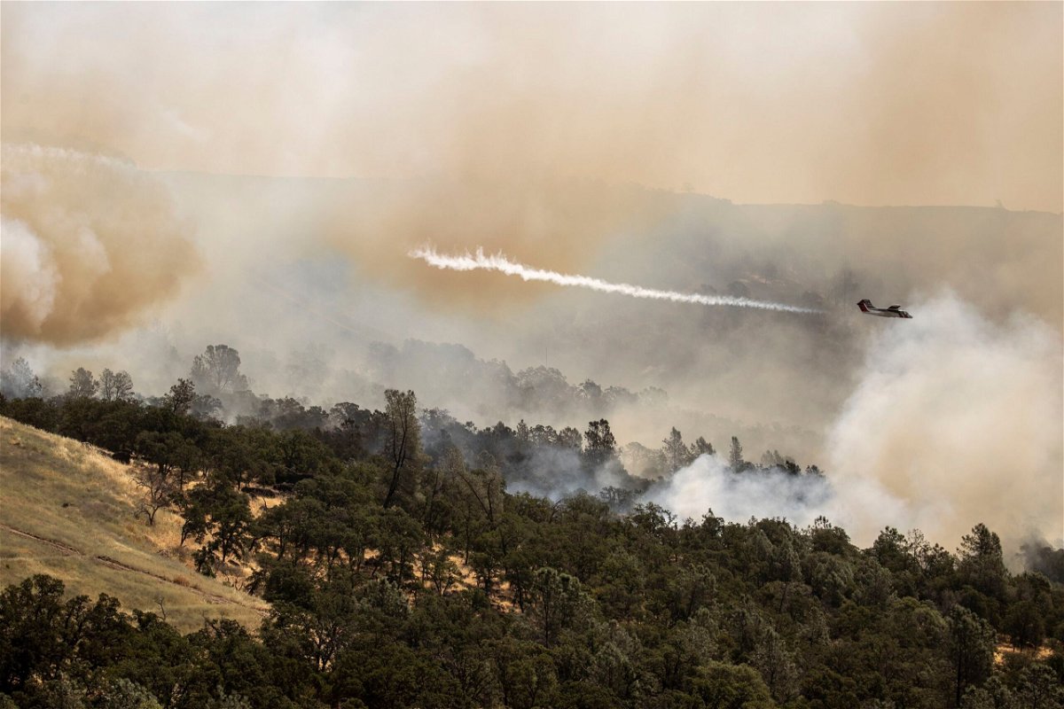 <i>Stephen Lam/San Francisco Chronicle/Getty Images via CNN Newsource</i><br/>A Cal Fire air tactical aircraft releases a puff of smoke while guiding a fire retardant drop during the Thompson Fire