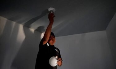 William Lee Tom Jr. screws in a lightbulb at his Navajo Nation home.