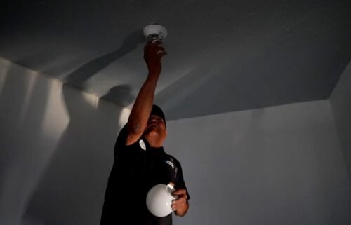 William Lee Tom Jr. screws in a lightbulb at his Navajo Nation home.