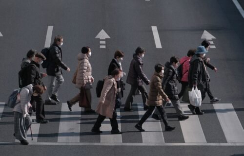Pedestrians cross an intersection in the Itabashi district of Tokyo